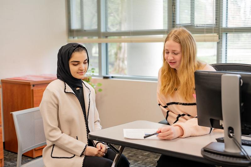 an advisor and a student sitting at a desk